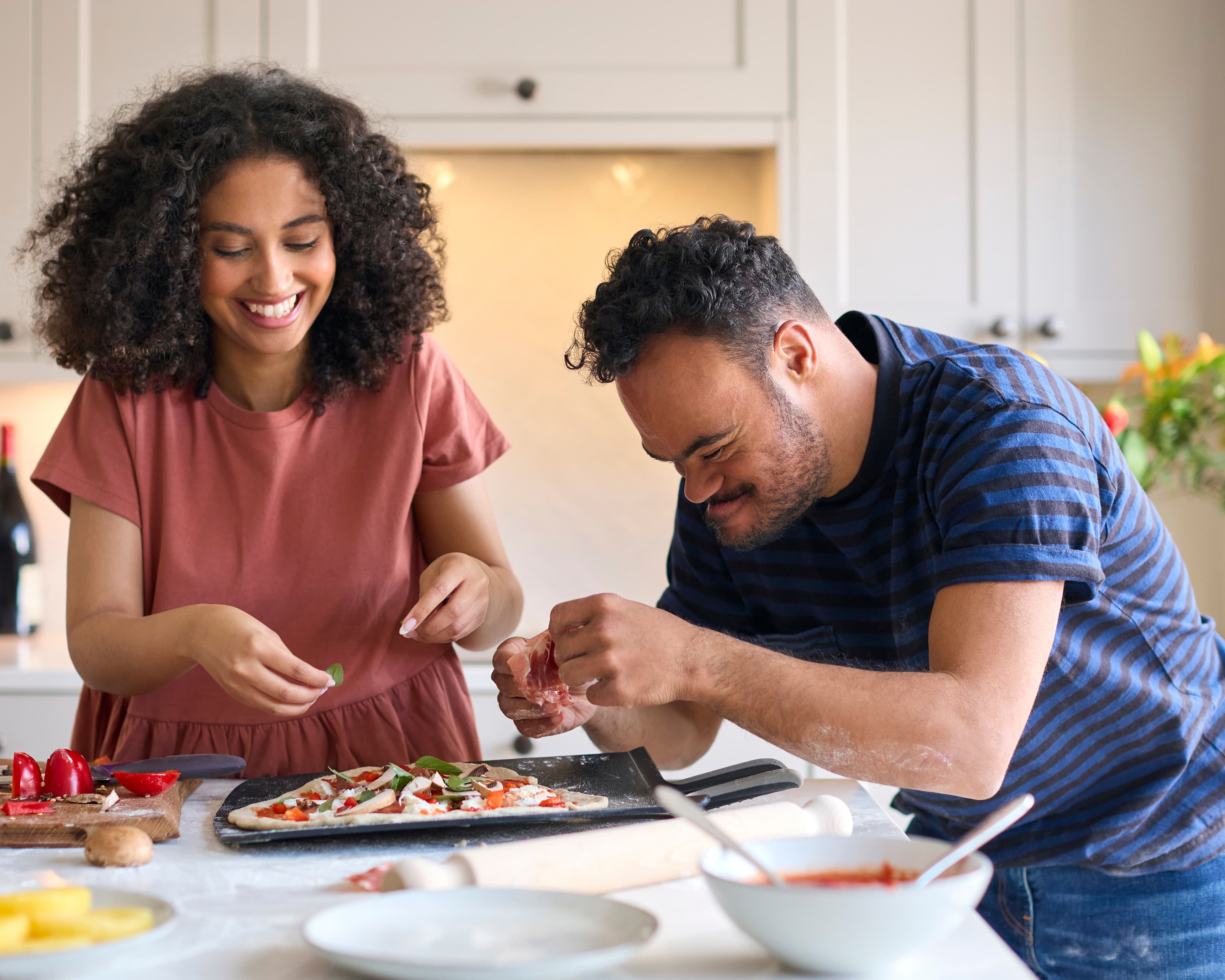 Support worker helping NDIS participant prepare a meal in the kitchen